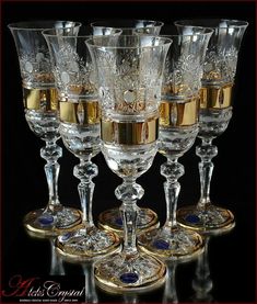 five wine glasses with gold rims are lined up