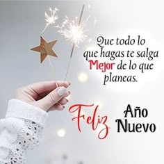 a person holding a sparkler with the words feliz nueveo written in spanish