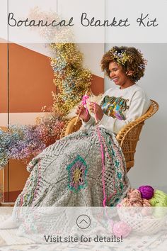 a woman sitting in a chair next to a pile of yarn and crochet