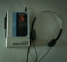 a sony walkman with headphones is laying on the floor