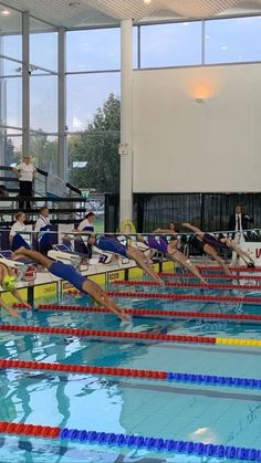 people are doing exercises in the swimming pool while others watch from the sidelines,