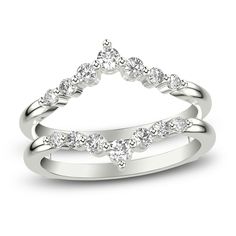 a white gold wedding ring set with three diamonds on each side and an open triangle shaped band