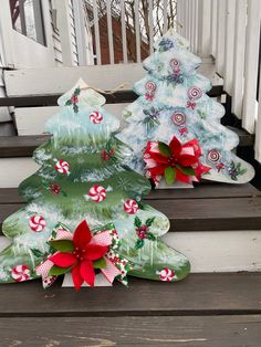 two decorated christmas trees sitting on the steps