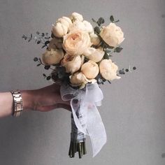 a person holding a bouquet of flowers in their left hand and the other hand is holding it