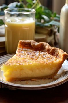 a piece of pie sitting on top of a plate next to a glass of orange juice