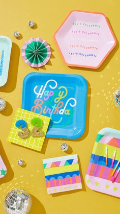 colorful party supplies laid out on a yellow surface