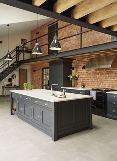 a kitchen with an island in the middle of it and brick walls on both sides