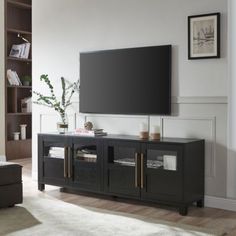 a flat screen tv sitting on top of a wooden entertainment center in a living room