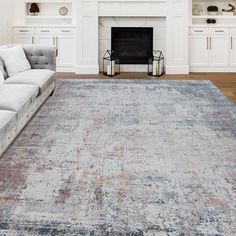 a living room with a couch, fireplace and rug on the floor in front of it