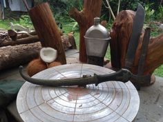 an old knife sitting on top of a table next to some wood and other items