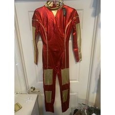 a red and gold jumpsuit hanging on a door