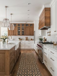 a kitchen with wooden cabinets and white counter tops, an area rug on the floor