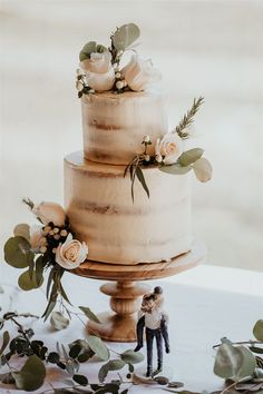 a wedding cake with white flowers and greenery