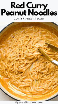 red curry peanut noodles in a skillet with a ladle full of the sauce