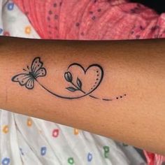 a woman's arm with a butterfly and heart tattoo on the left side of her arm