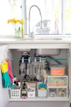 the kitchen sink is filled with cleaning supplies