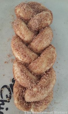 a stack of doughnuts sitting on top of a white tablecloth covered in powdered sugar