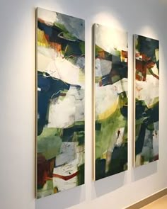 three paintings are hanging on the wall next to each other