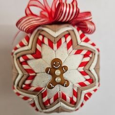 a christmas ornament with a gingerbread man on it's face and candy canes in the shape of a snowflake