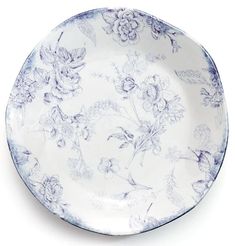 a blue and white plate with flowers on the rim, isolated against a white background