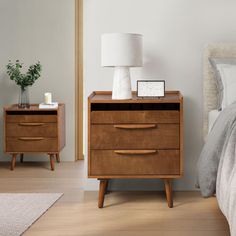 a bedroom with two nightstands and a lamp on the end table next to it