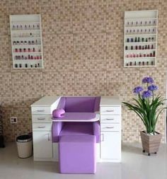 a purple chair sitting in front of a desk with drawers and shelves on the wall