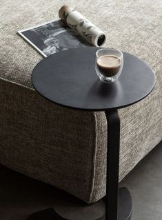 a table with a cup of coffee on top of it next to a magazine rack