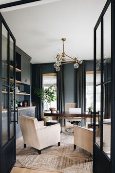 a living room filled with furniture and a chandelier hanging over it's windows