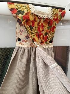 a dress hanging from the side of a microwave oven door with an apron on it