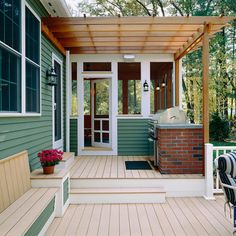 a porch with a grill and chairs on the front steps, next to a deck