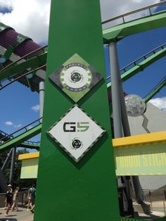 there is a sign that says g5 on the side of a green tower at an amusement park