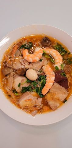 a white bowl filled with soup and shrimp