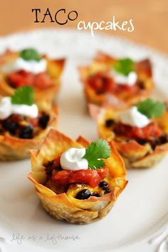 small appetizers on a white plate topped with sour cream and black olives