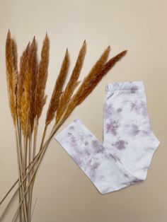 a pair of white pants sitting on top of a table next to some dry grass