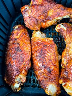 four pieces of cooked chicken sitting in a basket