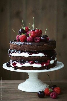 a chocolate cake with cherries and whipped cream