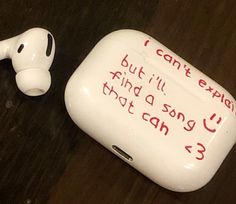 an earbud with writing on it sitting next to a small white object that says, i can't explain but i'll find a song you