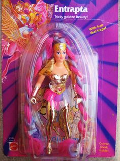 a barbie doll with pink hair and gold accents on it's body in a plastic package