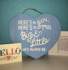 a heart shaped wooden sign with the words hello to you here's to me, big & little we'll always be