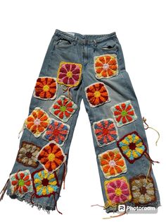 a pair of blue jeans with orange and red flowers on the side, all in different colors