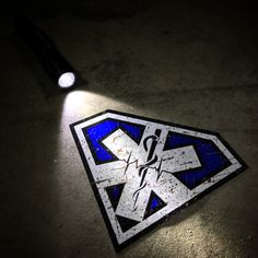 a blue and white sign sitting on top of a floor next to a black light