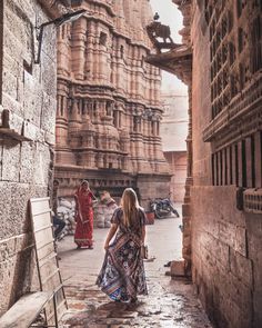 two women are walking through an alley way in the ancient city of jodhpur