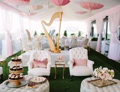 an elegant wedding reception with pink and white decor, cupcakes on gold trays