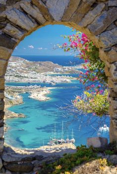 the view from an arch looking out at boats in the water