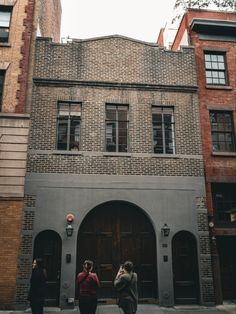 three people standing in front of a building