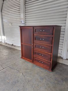 a large wooden dresser sitting in front of a garage door