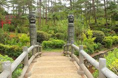 a stone bridge with two mailboxes on each side and trees in the background