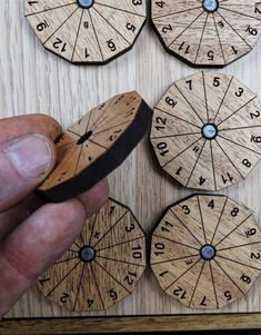 a hand is holding a piece of wood with numbers on it and two circles in the middle