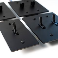 four black metal plates with screws on them