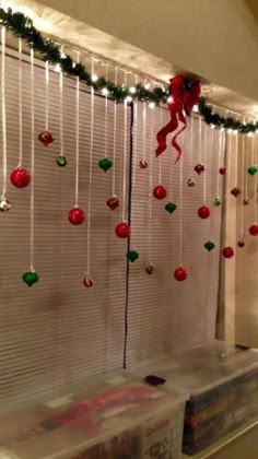 a window with christmas decorations hanging from it's sides and lights on the windowsill